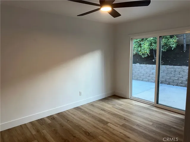 an empty room with a window and a fan