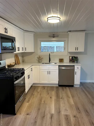 a kitchen with stainless steel appliances granite countertop a sink a stove top oven a counter space and cabinets