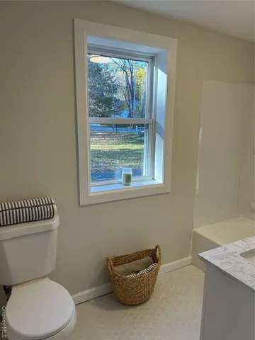 a white toilet sitting next to a window
