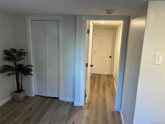 a view of a hallway with wooden floor and a mirror