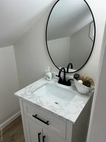 a bathroom with a granite countertop sink and mirror