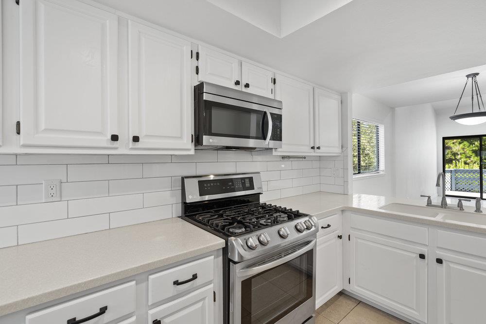 1313 Vía Tornasol Aptos, CA 95003 - Photo 11 of 38 a kitchen with granite countertop white cabinets and white stove
