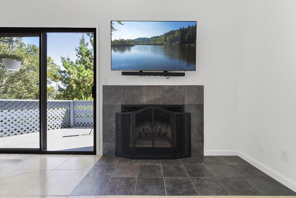 1313 Vía Tornasol Aptos, CA 95003 - Photo 18 of 38 a living room with a fireplace and a flat screen tv