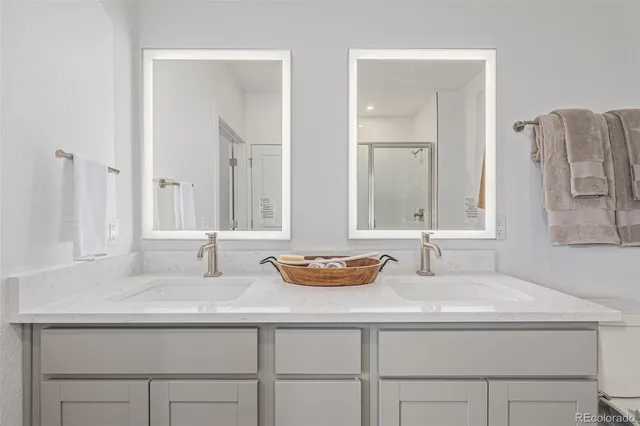 a bathroom with double vanity sinks and a mirror