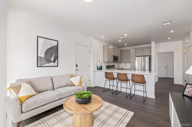 a living room with furniture and a dining table with wooden floor