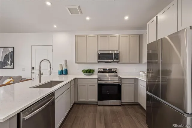 a kitchen with stainless steel appliances granite countertop a sink stove and refrigerator