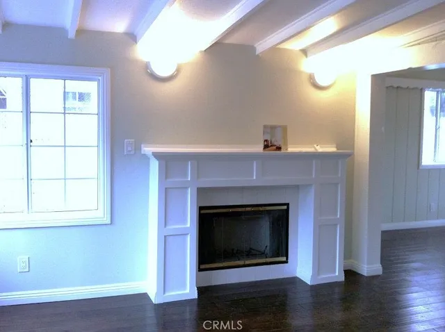 a living room with wooden floor and a fireplace