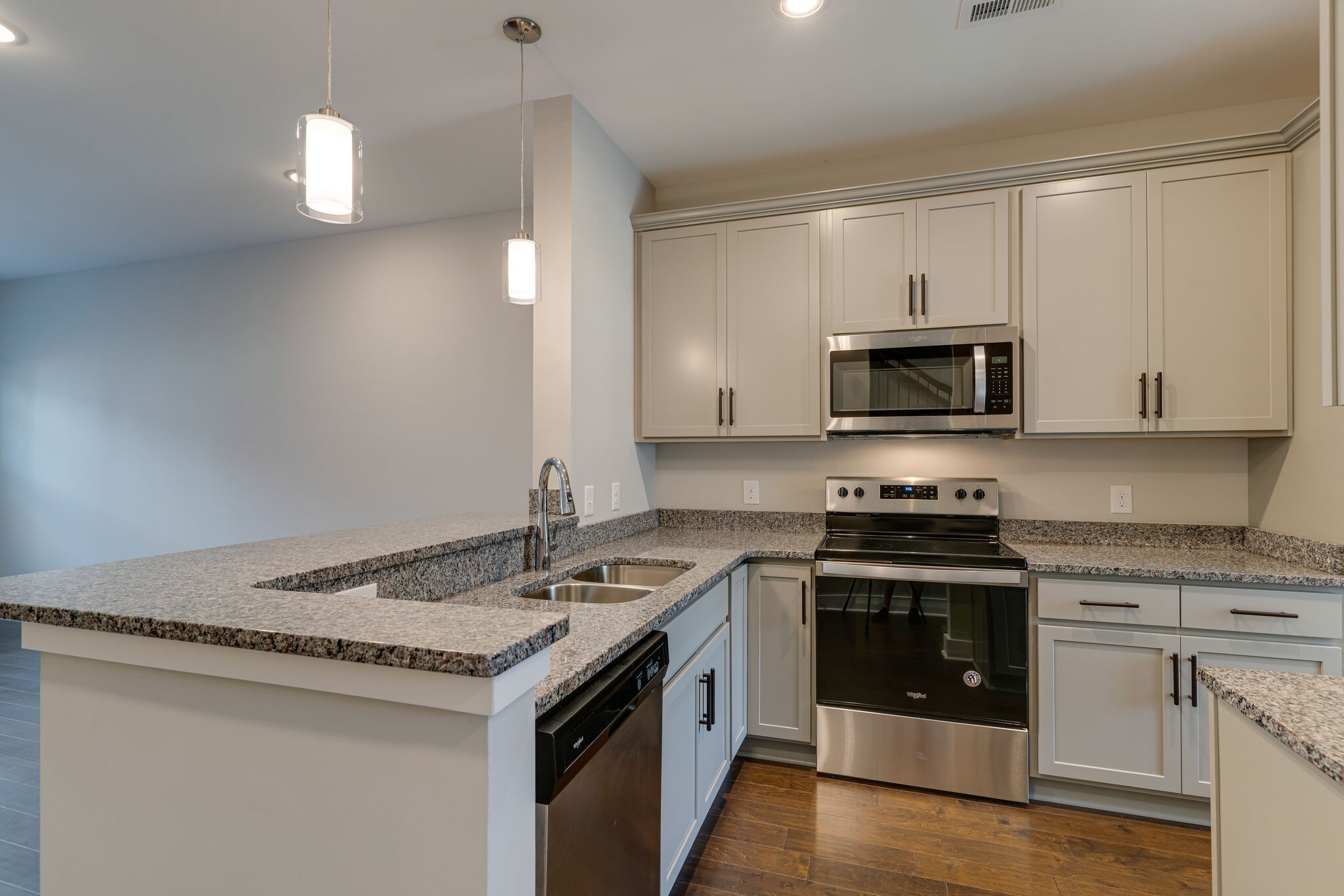 a kitchen with granite countertop a stove sink and microwave