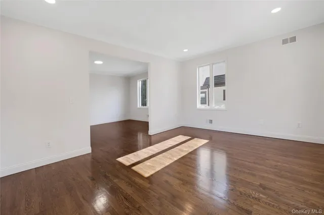 a hallway view with wooden floor and staircase