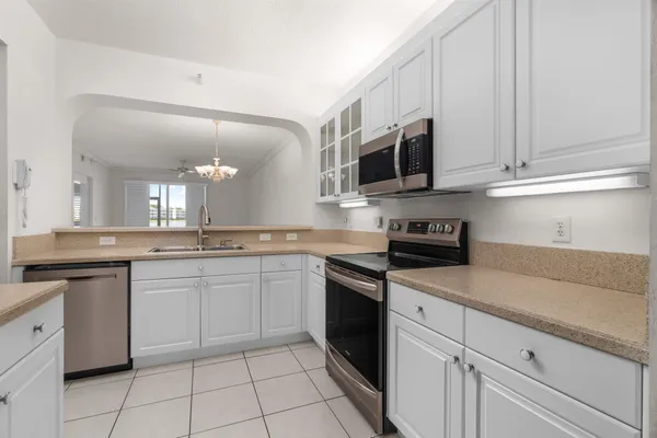 a kitchen with white cabinets and appliances