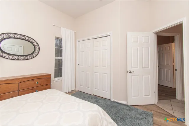 a spacious bedroom with a bed and a dresser