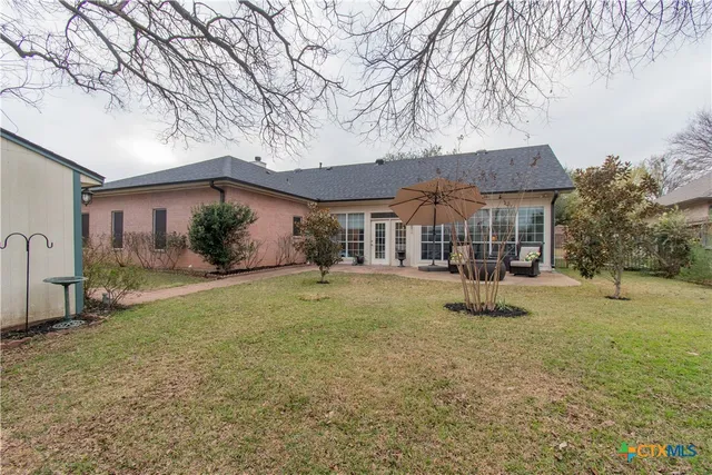 a backyard of a house with table and chairs