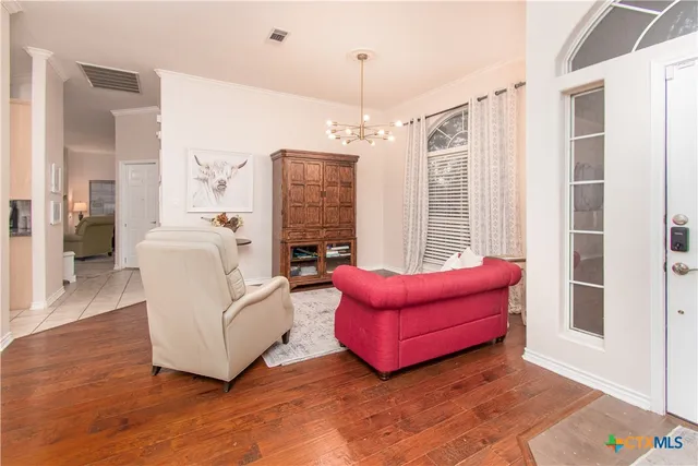 a living room with furniture and a chandelier