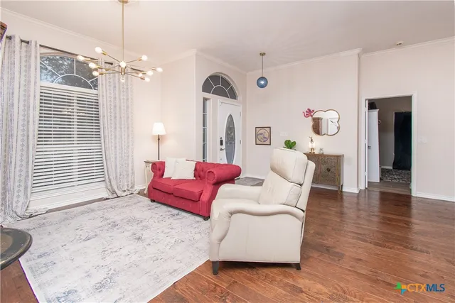 a living room with furniture and a chandelier