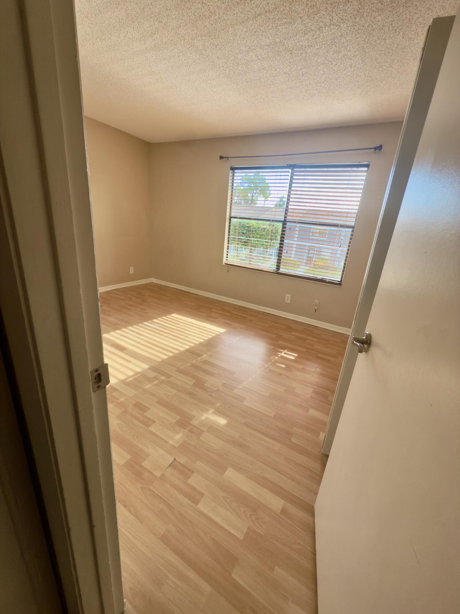 799 Hill Drive, Unit F West Palm Beach, FL 33415 - Photo 11 of 14 a view of empty room with wooden floor and fan