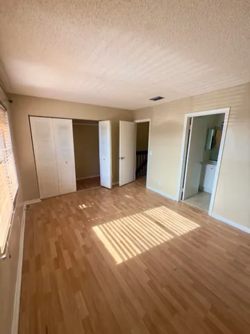a view of a livingroom with wooden floor and kitchen