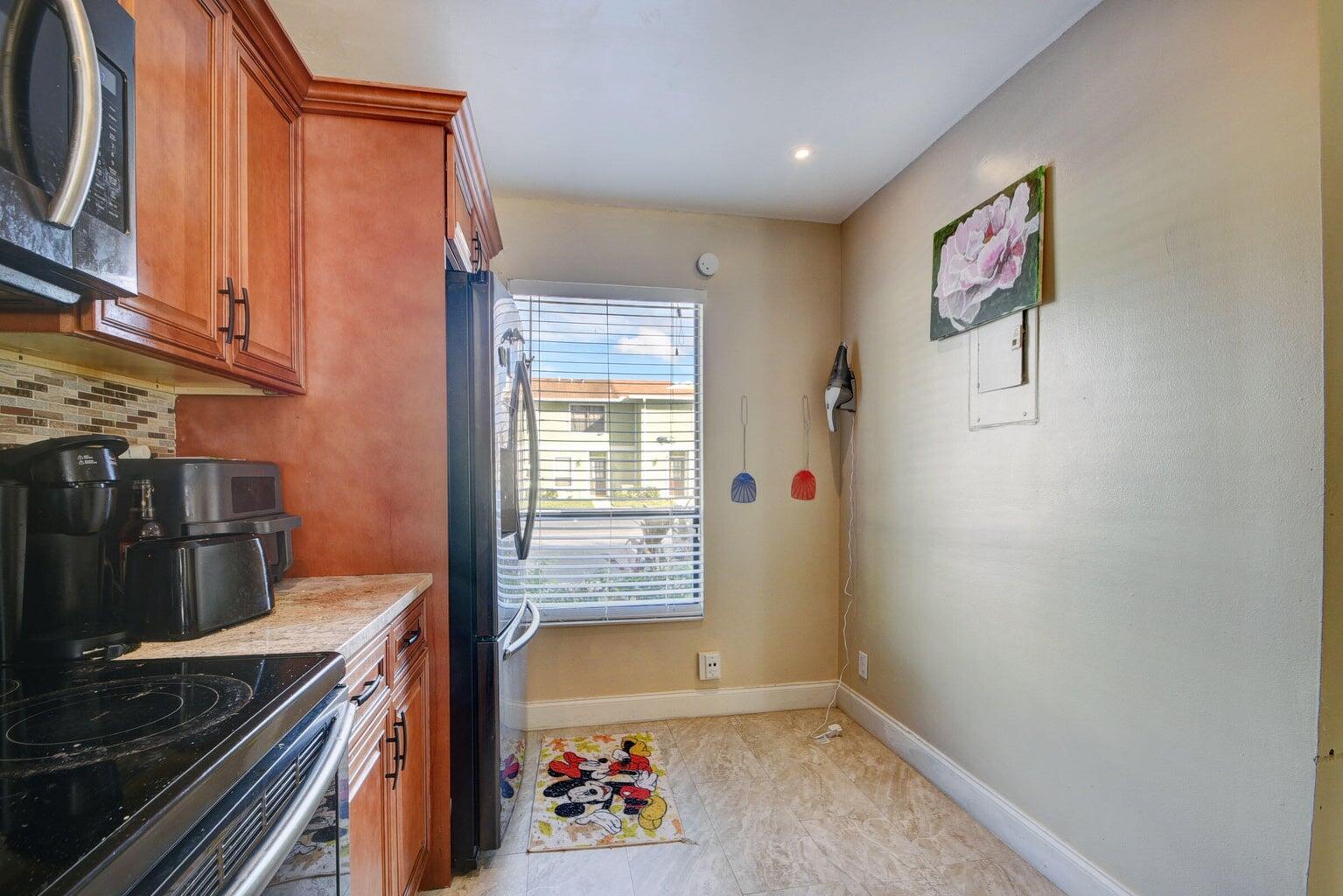 799 Hill Drive, Unit F West Palm Beach, FL 33415 - Photo 3 of 14 a kitchen with a refrigerator and a stove