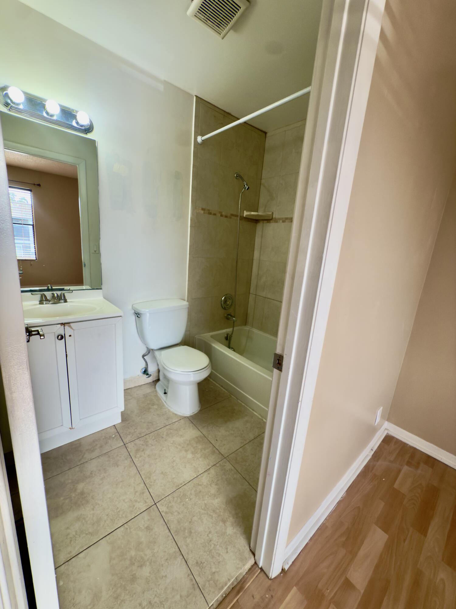 799 Hill Drive, Unit F West Palm Beach, FL 33415 - Photo 8 of 14 a bathroom with a sink a toilet and shower