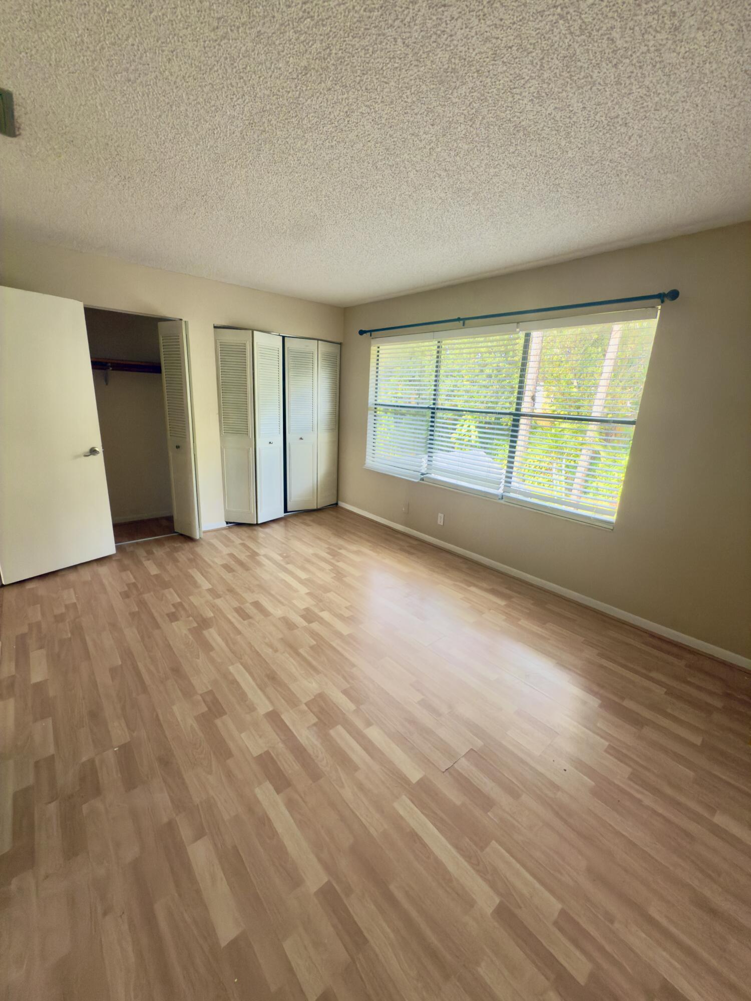 799 Hill Drive, Unit F West Palm Beach, FL 33415 - Photo 9 of 14 a view of an empty room with a window and wooden floor
