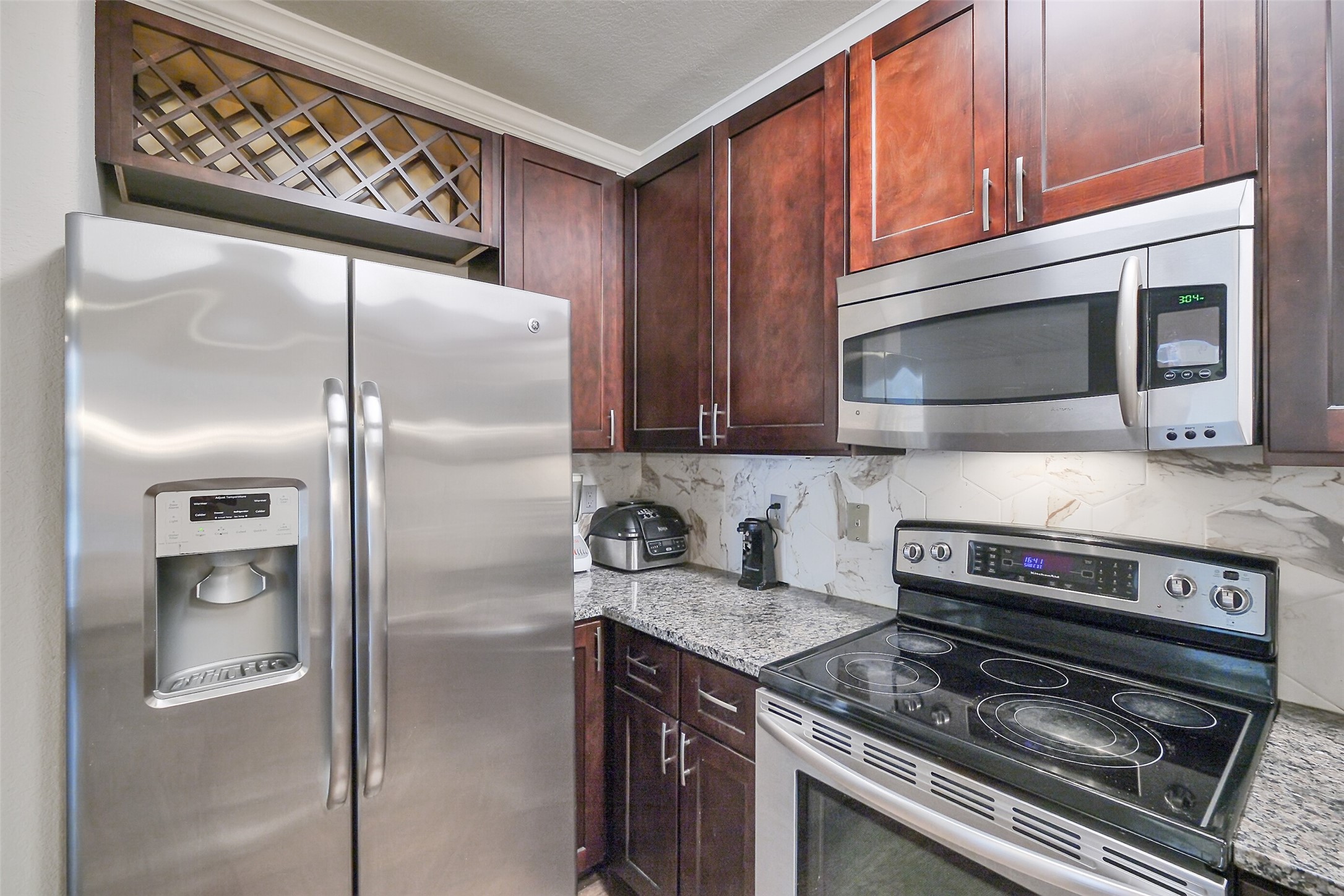 1711 Old Spanish Trail, Unit 128 Houston, TX 77054 - Photo 9 of 26 a kitchen with stainless steel appliances granite countertop a stove microwave and refrigerator