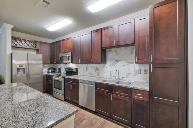 a kitchen with stainless steel appliances granite countertop a refrigerator stove a sink and dishwasher
