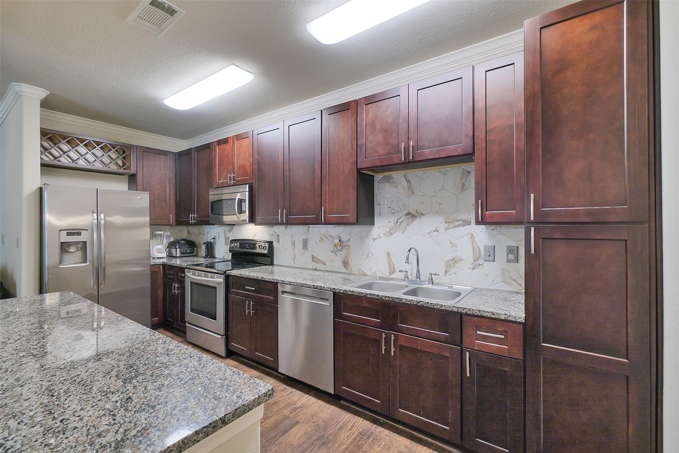 1711 Old Spanish Trail, Unit 128 Houston, TX 77054 - Photo 10 of 26 a kitchen with stainless steel appliances granite countertop a refrigerator stove a sink and dishwasher