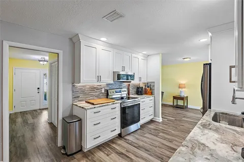 a kitchen with stainless steel appliances granite countertop a stove a sink and a refrigerator
