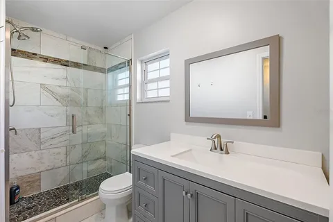 a bathroom with a sink a toilet and shower