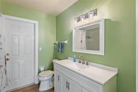 a bathroom with a sink vanity mirror and toilet