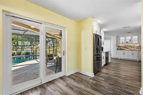 a view of a kitchen with a refrigerator wooden floor and a kitchen