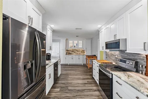 a kitchen with stainless steel appliances a refrigerator stove and microwave