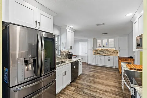 a kitchen with stainless steel appliances a refrigerator sink and cabinets