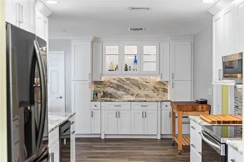 a kitchen with stainless steel appliances granite countertop a refrigerator and a stove top oven