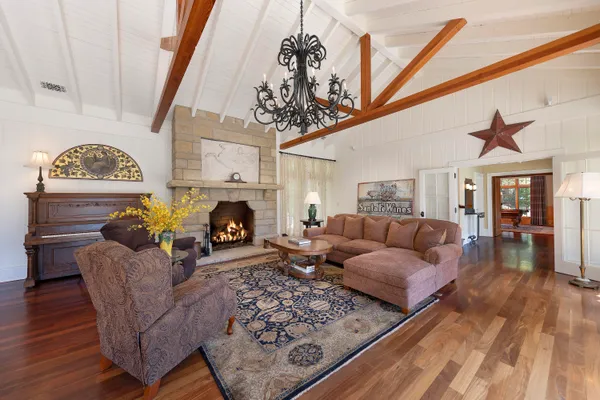 a living room with furniture a fireplace and a chandelier