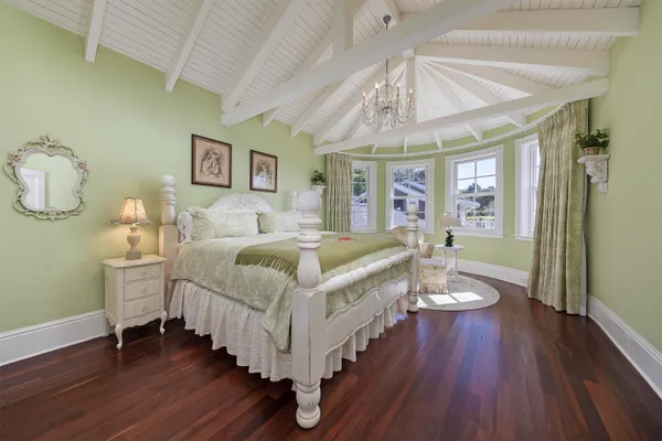 a spacious bedroom with a bed and a chandelier