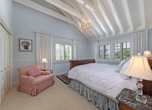 a spacious bedroom with a bed and a chandelier