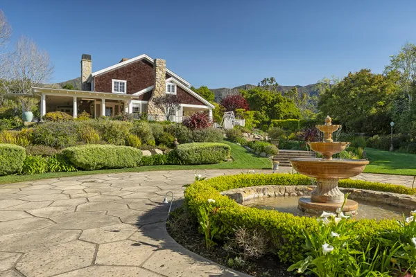 a front view of a house with a garden