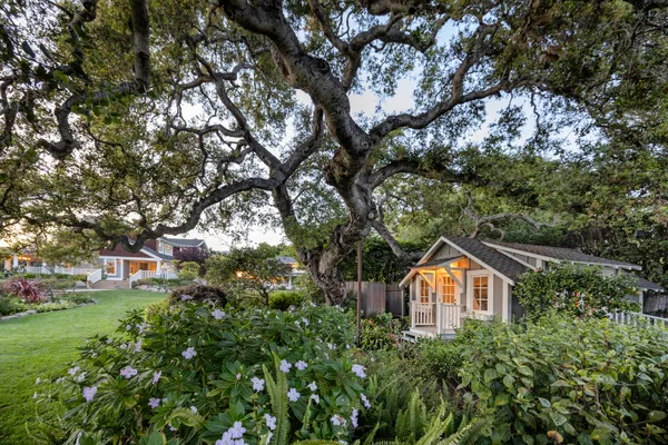 an aerial view of a house with a yard and large trees