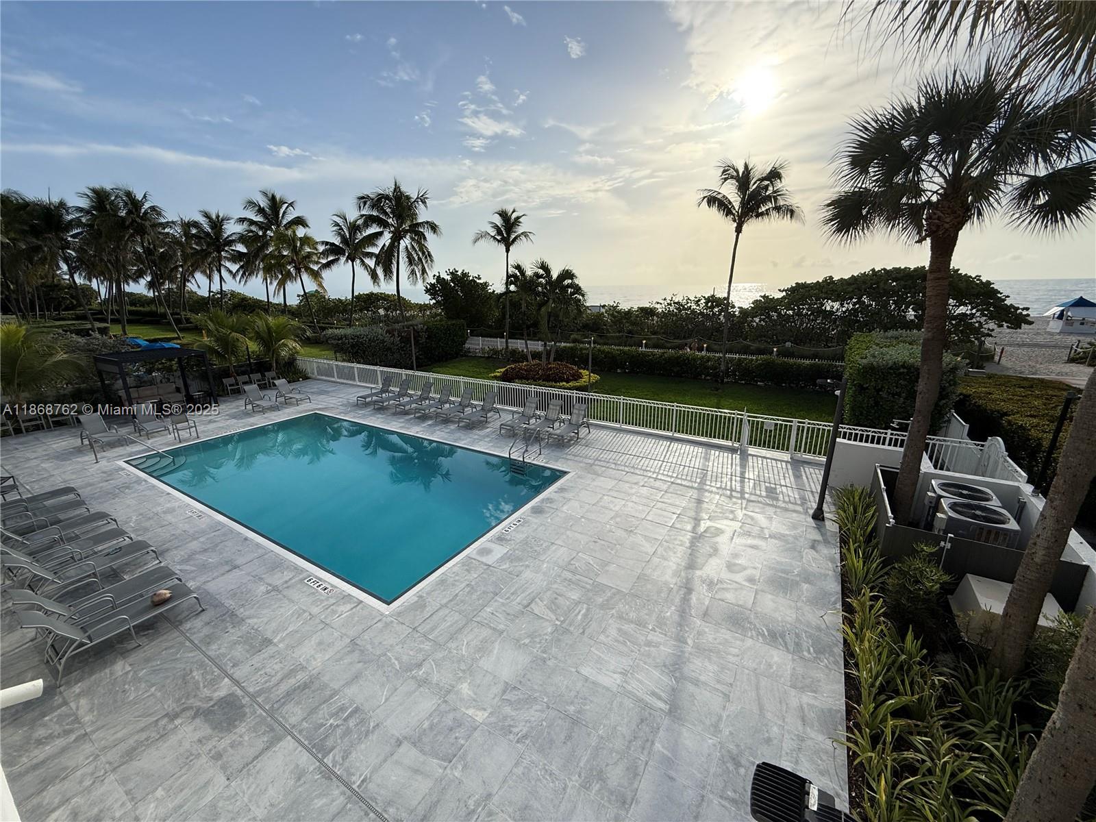 4301 Collins Avenue, Unit 208 Miami Beach, FL 33140 - Photo 22 of 28 a view of a swimming pool with a table and chairs