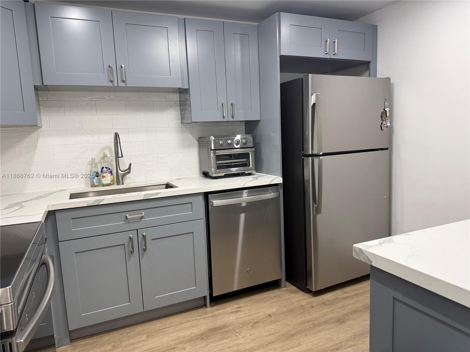 4301 Collins Avenue, Unit 208 Miami Beach, FL 33140 - Photo 4 of 28 a kitchen with a refrigerator sink and cabinets