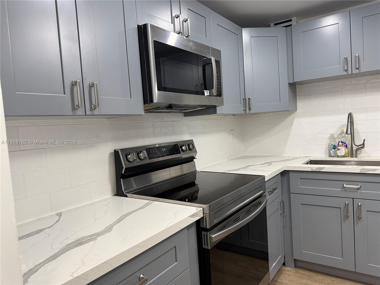 4301 Collins Avenue, Unit 208 Miami Beach, FL 33140 - Photo 5 of 28 a kitchen with a sink and a microwave
