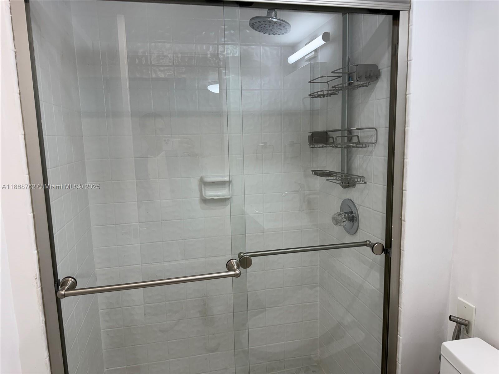 4301 Collins Avenue, Unit 208 Miami Beach, FL 33140 - Photo 10 of 28 a bathroom with a glass shower door