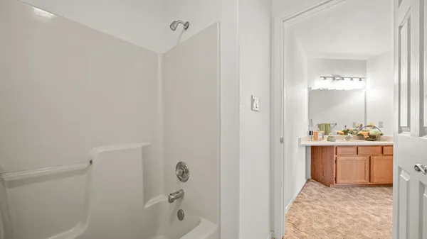 a bathroom with a tub sink and mirror