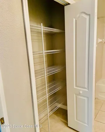 a view of a hallway with wooden floor and cabinet
