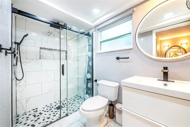 a bedroom with a bed potted plants on the dresser and a large window