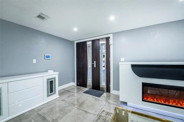 a view of an empty room with fireplace and a window