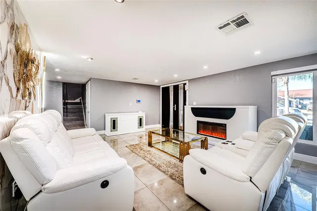 a living room with furniture a flat screen tv and kitchen view
