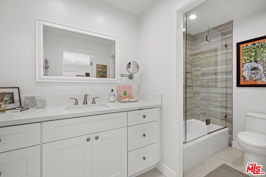 6795 Las Olas Way Malibu, CA 90265 - Photo 16 of 26 a bathroom with a granite countertop sink a toilet and a bathtub