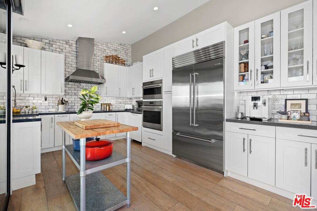 6795 Las Olas Way Malibu, CA 90265 - Photo 9 of 26 a kitchen with stainless steel appliances granite countertop a kitchen island wooden cabinets and a refrigerator
