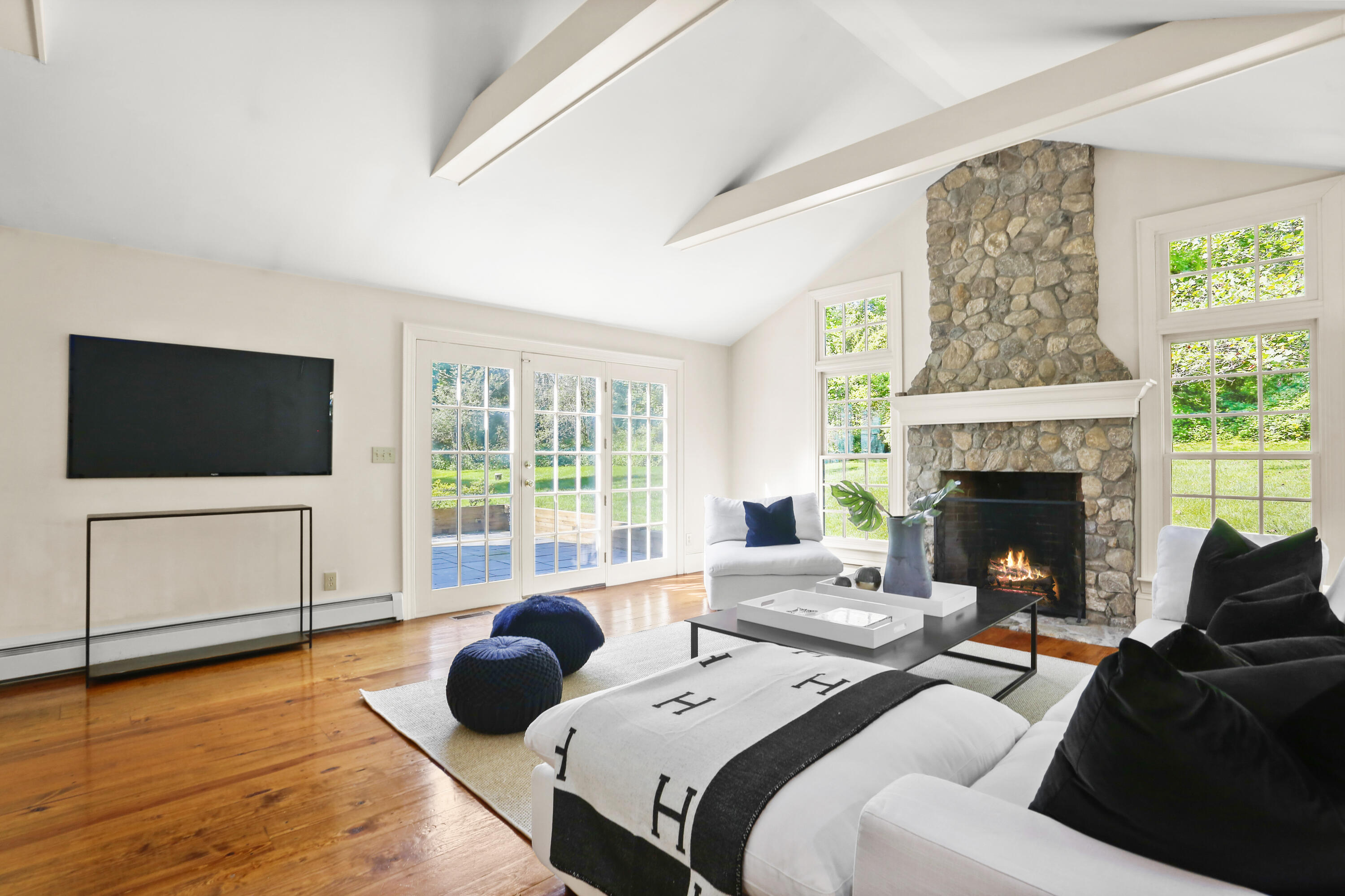 110 Sleepy Hollow Road New Canaan, CT 06840 - Photo 17 of 47 a living room with a couch a flat screen tv and a fireplace